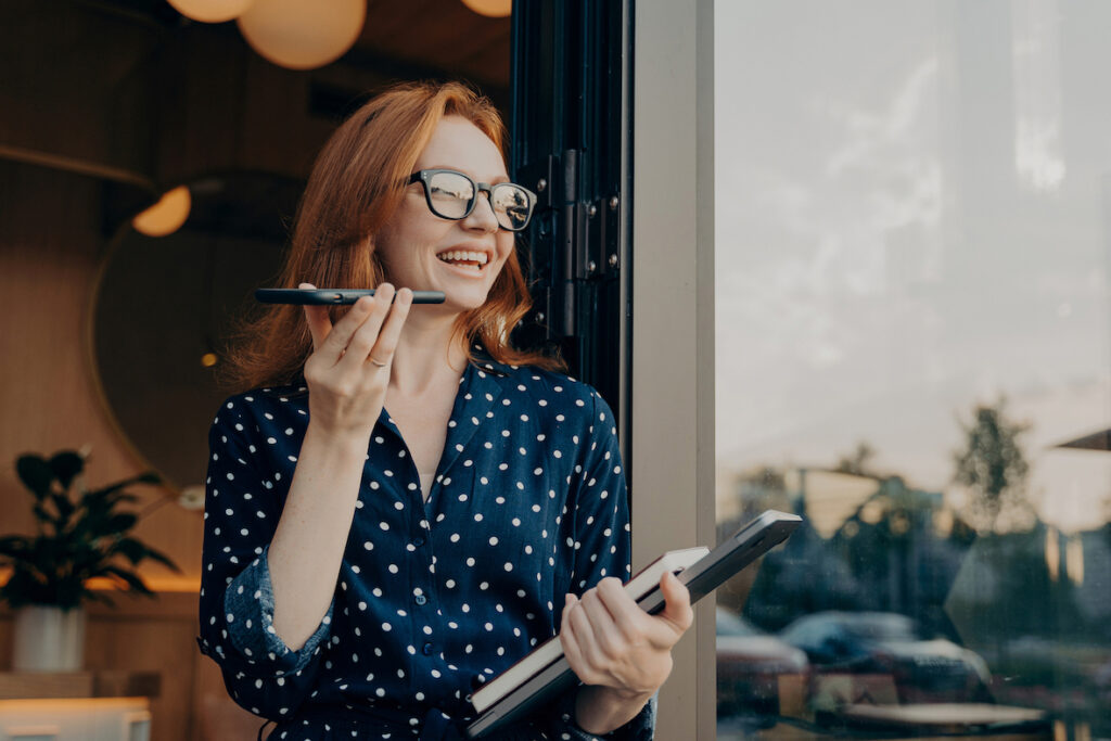 Eine Frau, die für ihre täglichen Anrufe eine Sprache-zu-Text-App verwendet